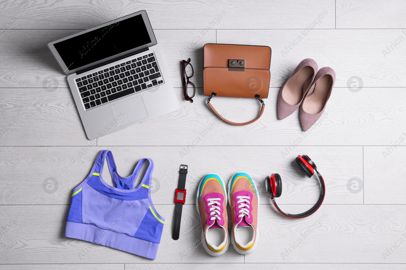 Photo of Flat lay composition with business supplies and sport equipment on white wooden floor. Concept of balance between work and life