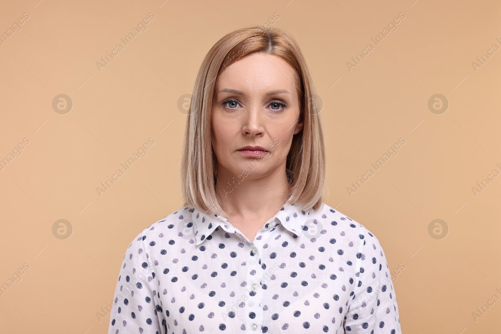 Photo of Portrait of sad woman on beige background