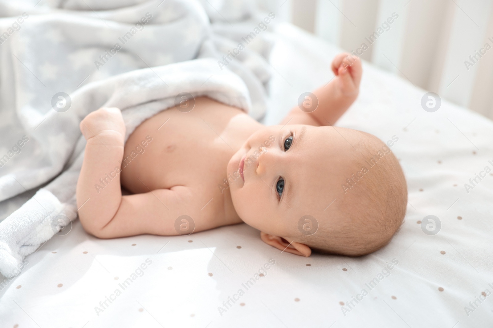 Photo of Cute little baby lying in crib at home