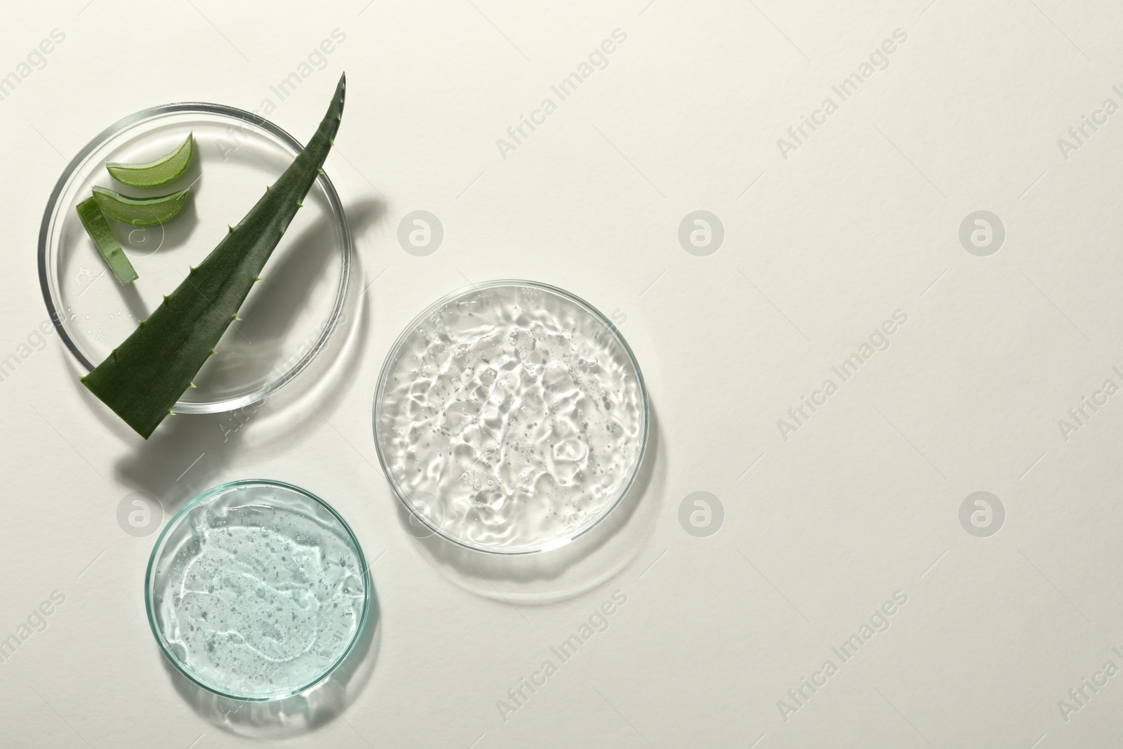 Photo of Flat lay composition with cosmetic gel and aloe on white background, space for text