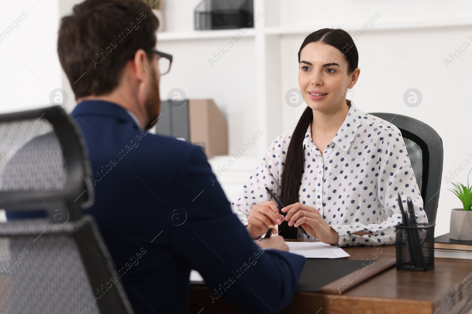 Photo of Woman having meeting with lawyer in office, selective focus