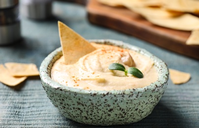 Photo of Delicious homemade hummus in bowl on wooden table