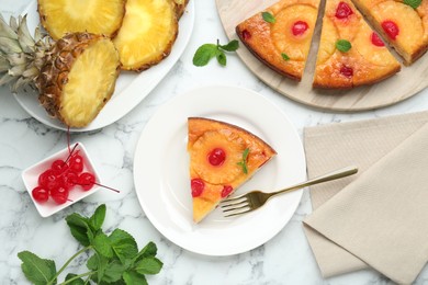 Delicious cut pineapple pie with cherry and mint on white marble table, flat lay