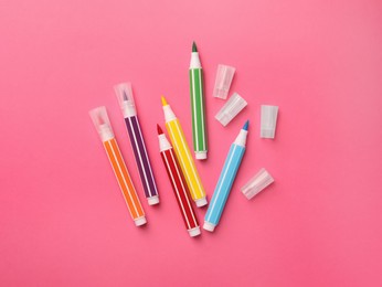 Photo of Many bright markers on pink background, flat lay