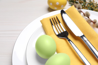 Photo of Festive Easter table setting with eggs on white wooden background, closeup
