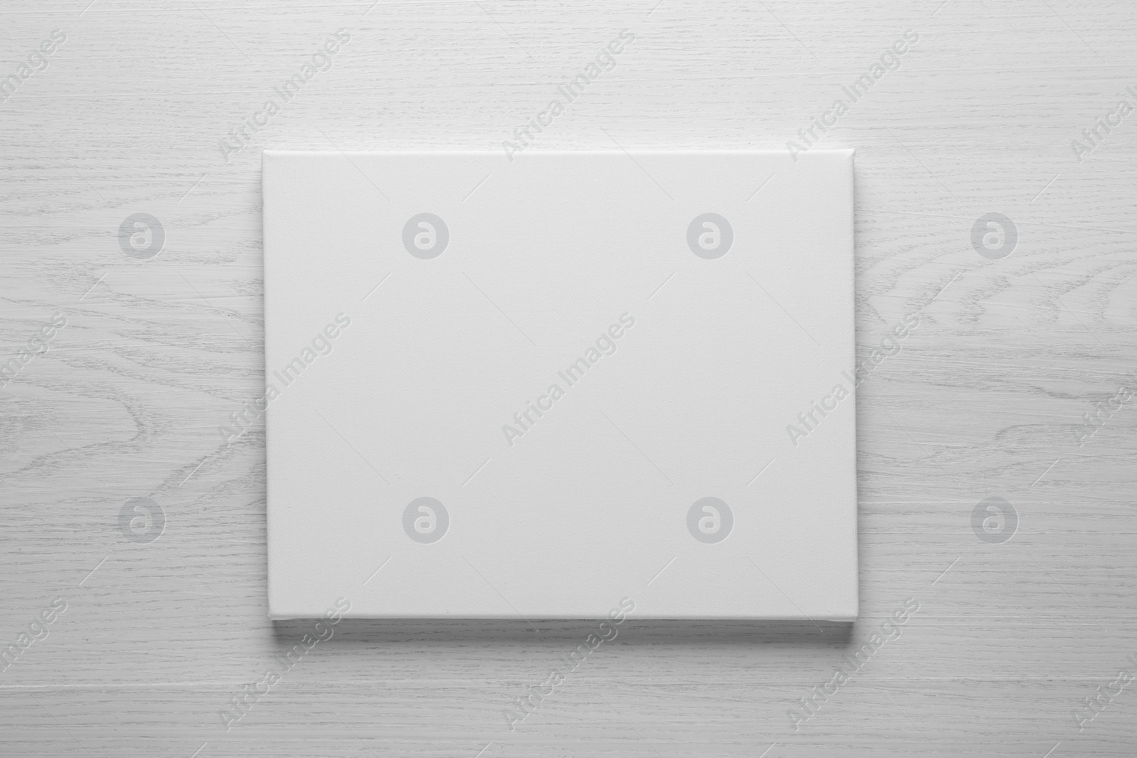 Photo of Blank canvas on white wooden background, space for text