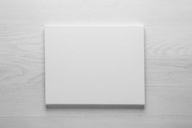 Photo of Blank canvas on white wooden background, space for text