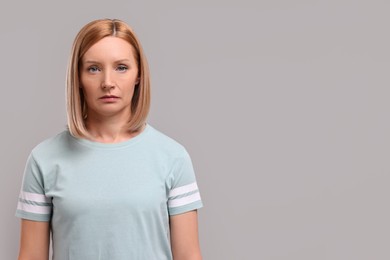 Photo of Portrait of sad woman on grey background. Space for text