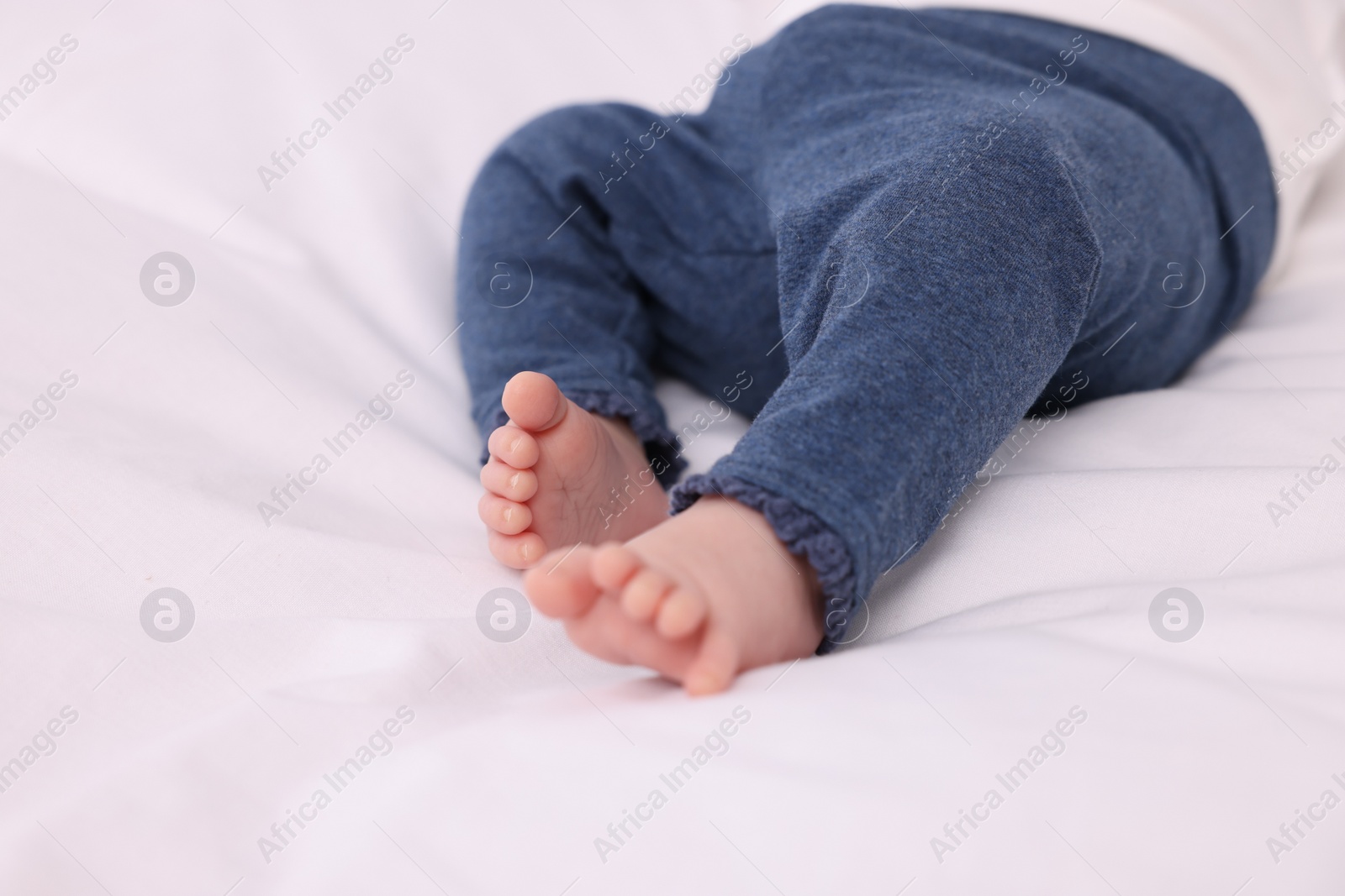 Photo of Newborn baby lying on white blanket, closeup