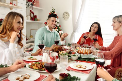 Photo of Happy family with their friends enjoying festive dinner at home. Christmas Eve celebration