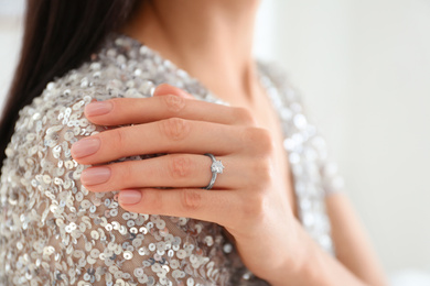 Young woman wearing beautiful engagement ring, closeup