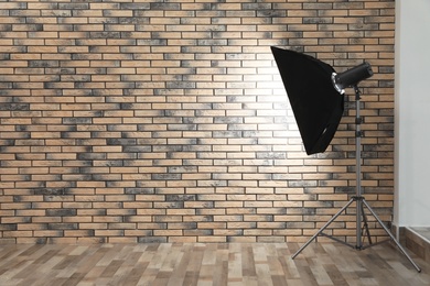 Professional lighting equipment near wall in photo studio. Space for text