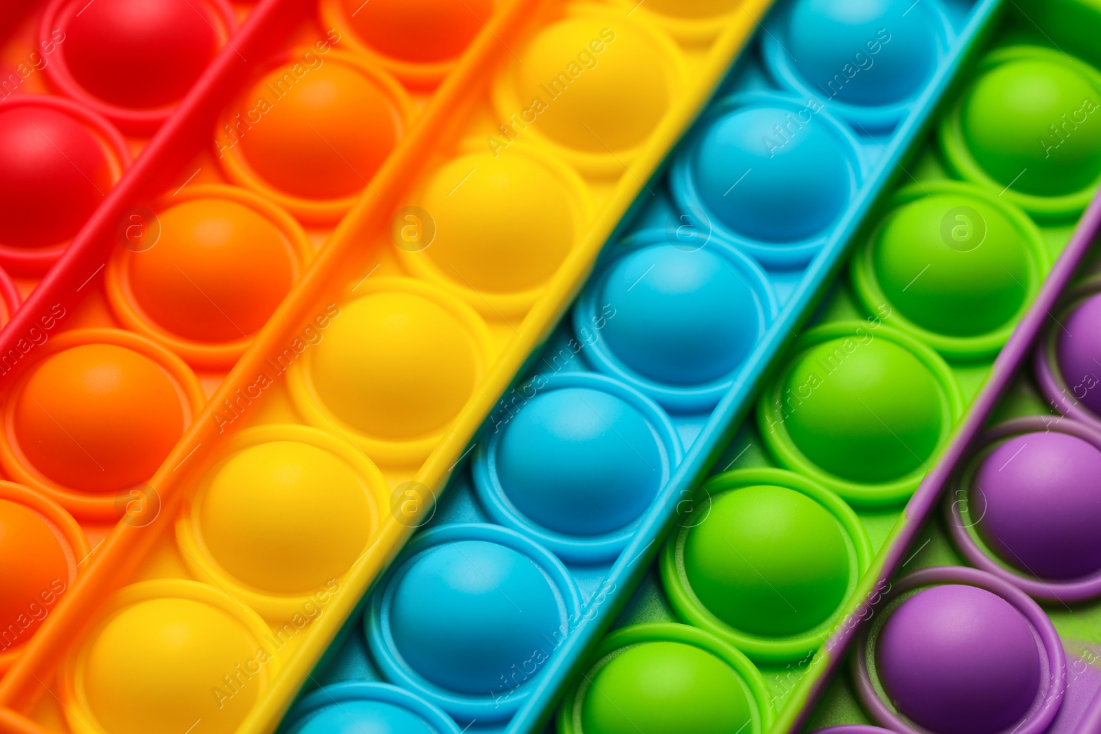Photo of Rainbow pop it fidget toy as background, closeup