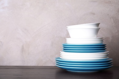 Photo of Set of dinnerware on table against grey background with space for text. Interior element