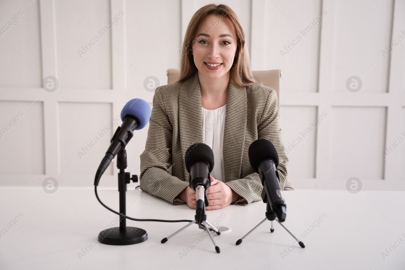 Photo of Happy young woman giving interview at official event