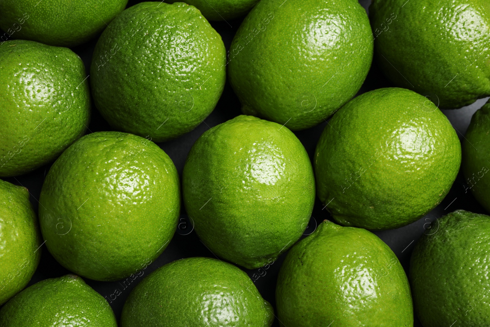 Photo of Fresh ripe green limes as background, top view