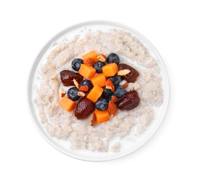 Photo of Delicious barley porridge with blueberries, pumpkin, dates and almonds in bowl isolated on white, top view