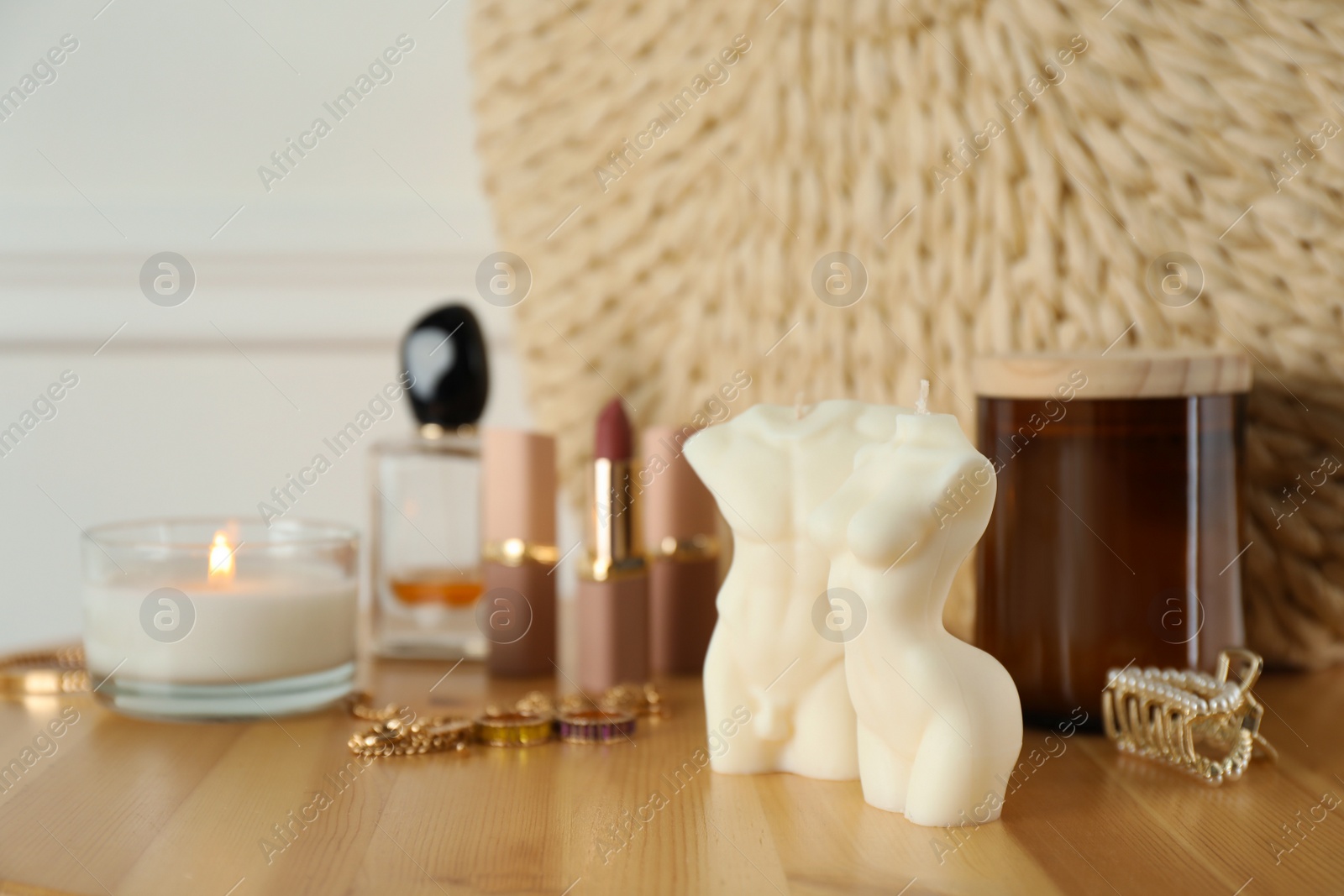 Photo of Beautiful female and male body shaped candles on wooden table. Stylish decor