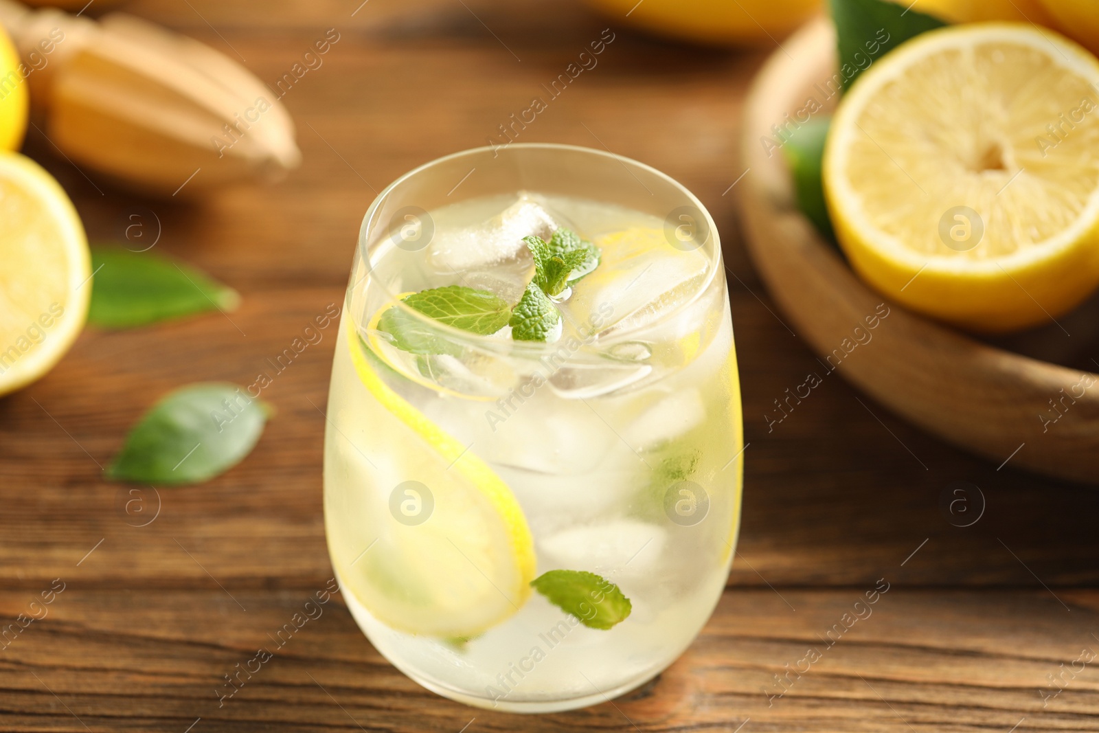 Photo of Cool freshly made lemonade in glass on wooden table, closeup