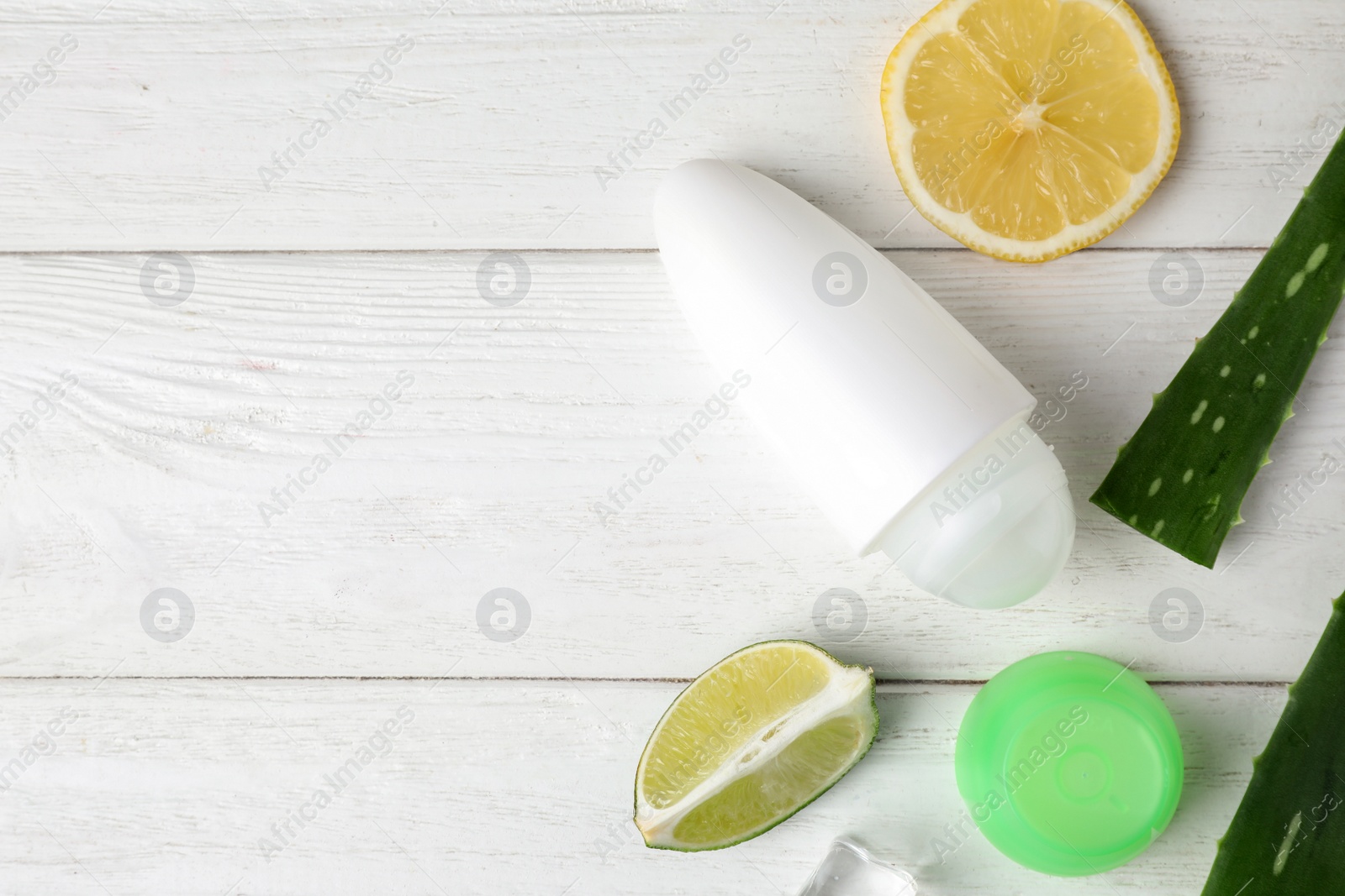 Photo of Flat lay composition with natural roll-on deodorant on white wooden table, space for text