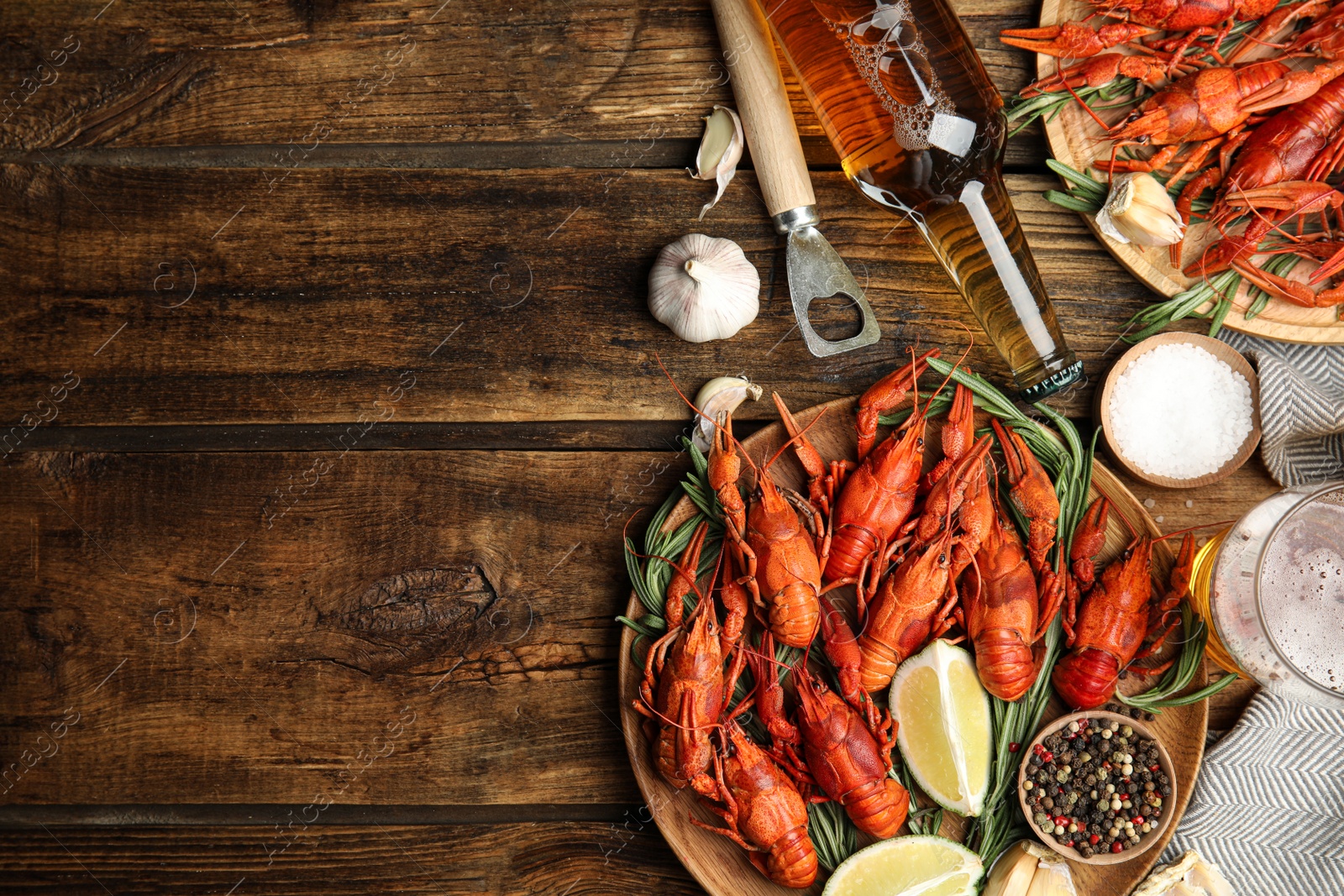 Photo of Flat lay composition with delicious red boiled crayfishes on wooden table, space for text
