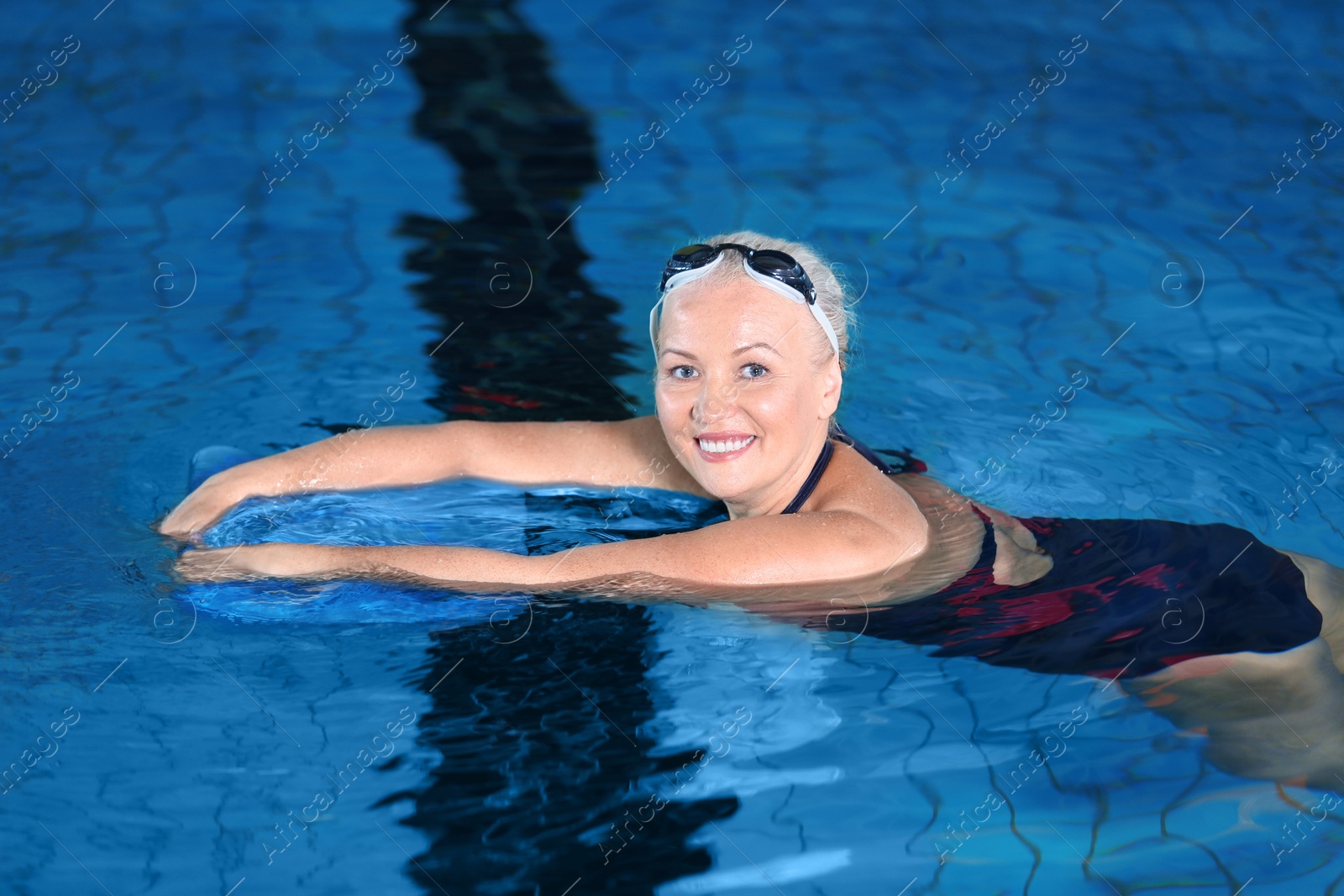 Photo of Sportive senior woman in indoor swimming pool
