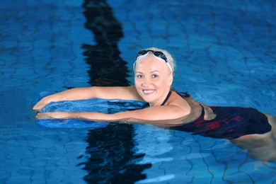 Photo of Sportive senior woman in indoor swimming pool