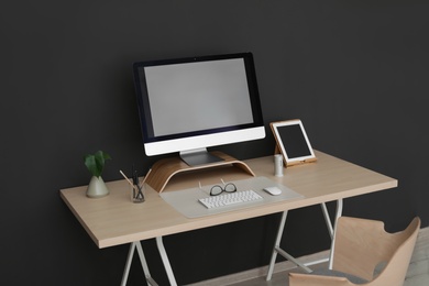 Photo of Modern workplace interior with computer on table. Space for text