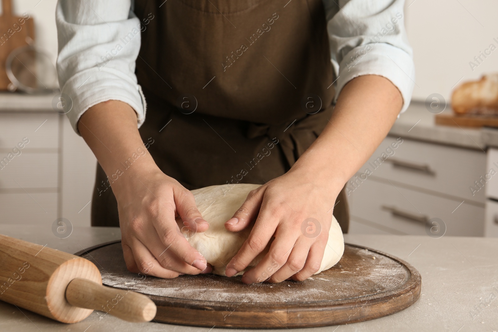 Photo of Female baker preparing bread dough at table, closeup