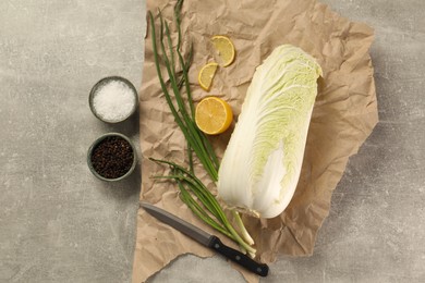 Photo of Fresh Chinese cabbage, lemon, green onion and spices on light grey table, flat lay