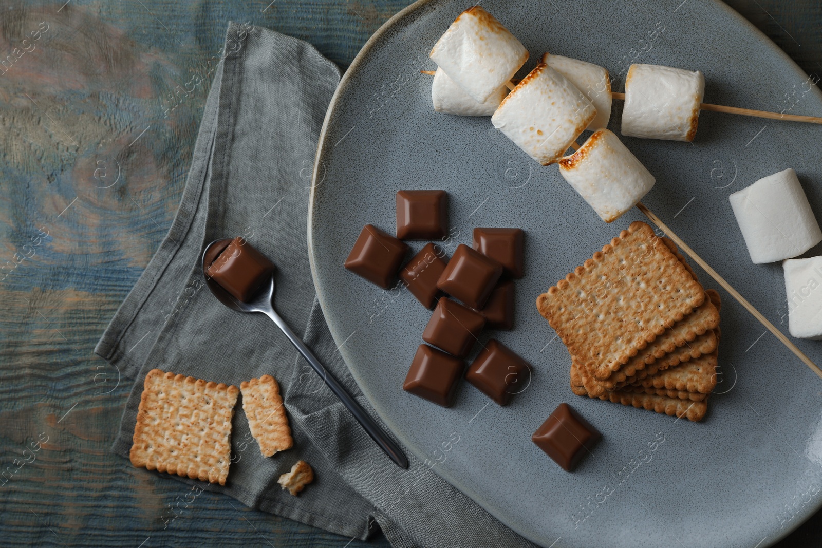 Photo of Ingredients for delicious sandwich with roasted marshmallows and chocolate on grey wooden table, flat lay