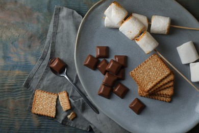 Ingredients for delicious sandwich with roasted marshmallows and chocolate on grey wooden table, flat lay
