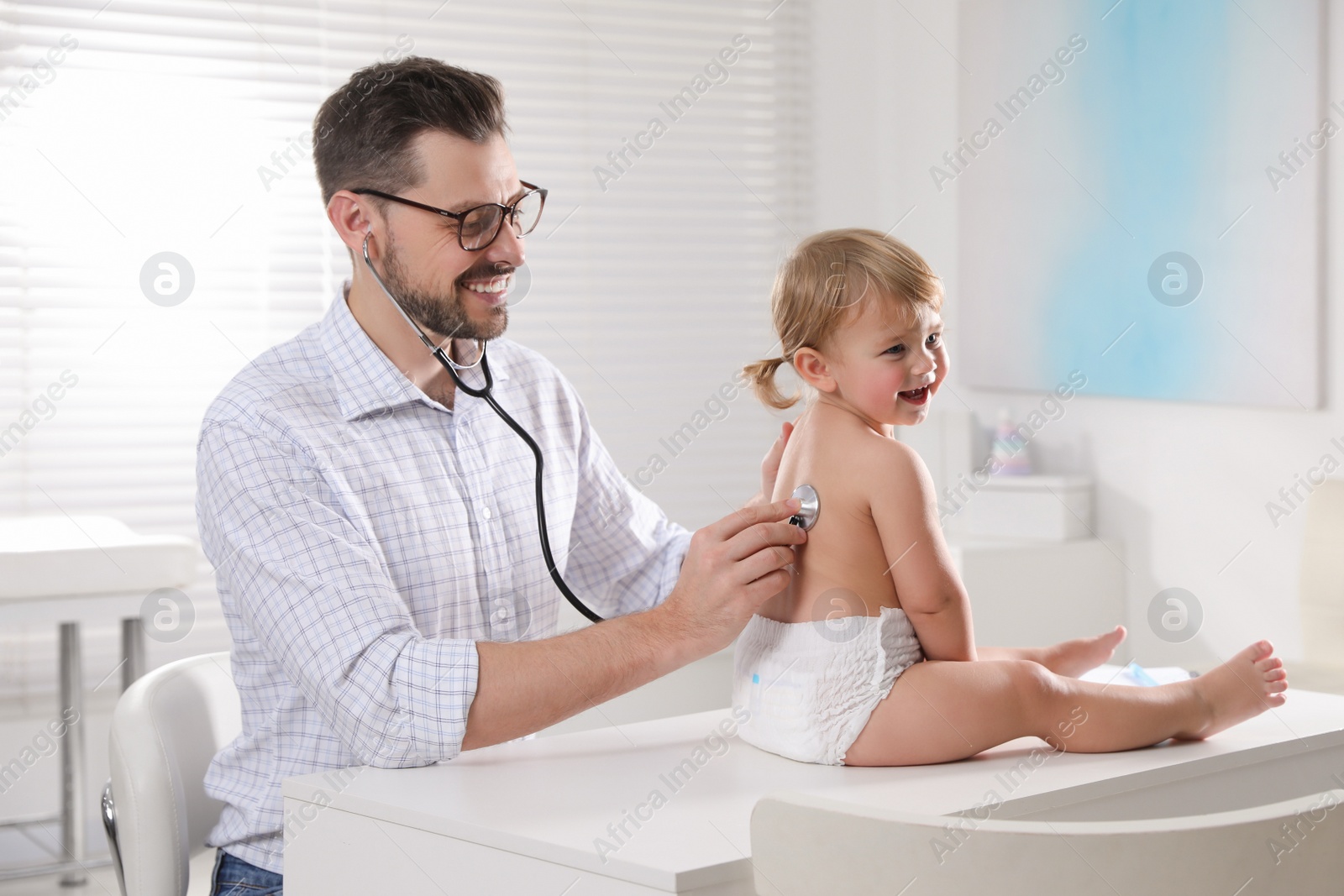 Photo of Pediatrician examining baby with stethoscope in clinic