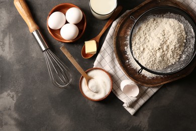 Different ingredients for dough on grey textured table, flat lay