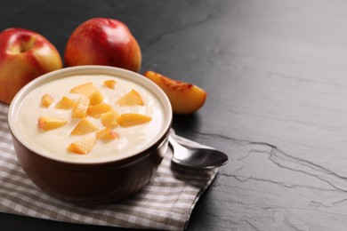 Delicious yogurt with fresh peach on black table, space for text