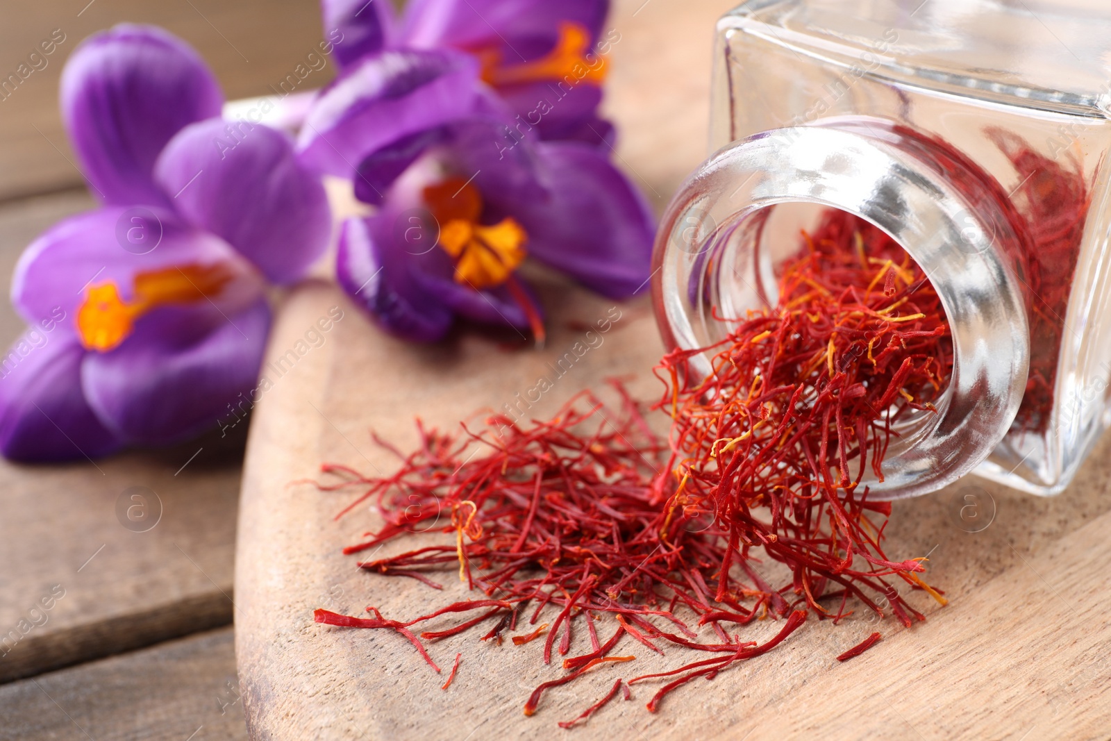 Photo of Dried saffron and crocus flowers on wooden table, closeup. Space for text