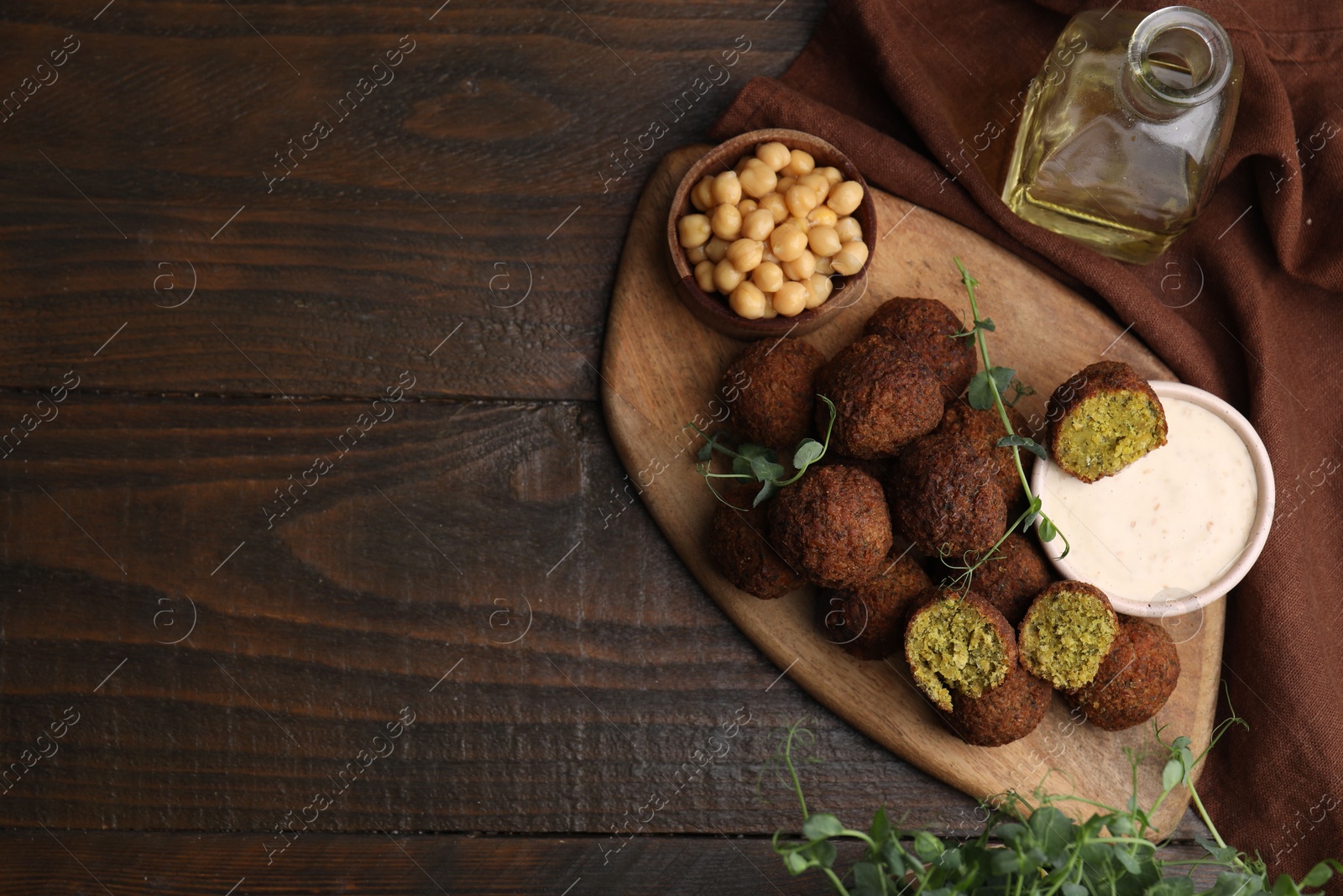 Photo of Delicious falafel balls served on wooden table, top view. Space for text