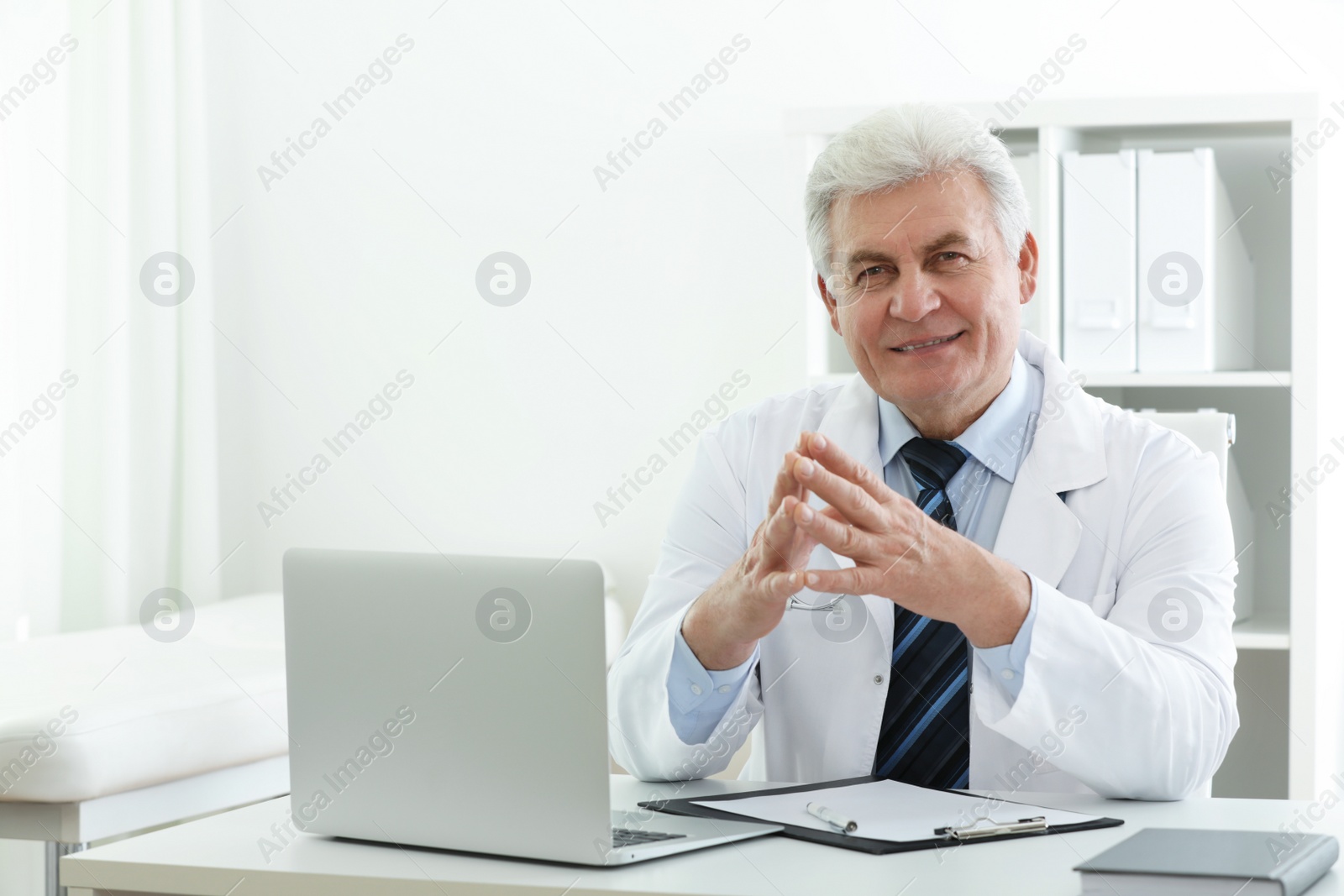 Photo of Portrait of senior doctor in white coat at workplace