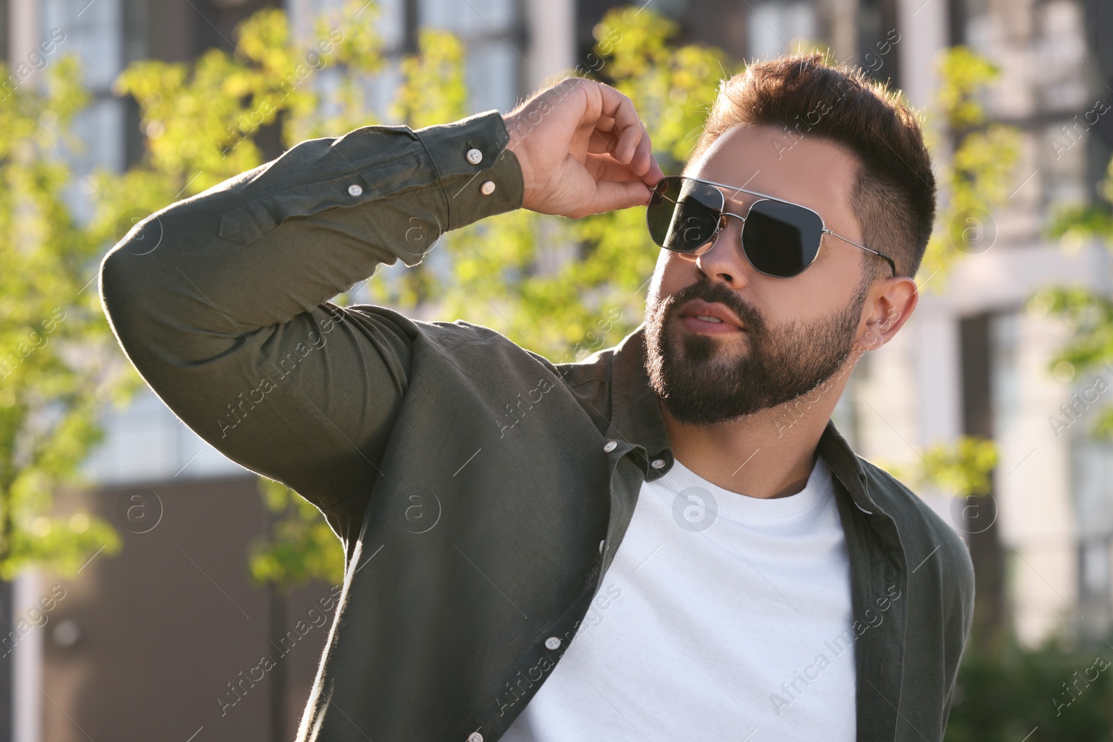 Photo of Handsome young man in sunglasses outdoors on sunny day