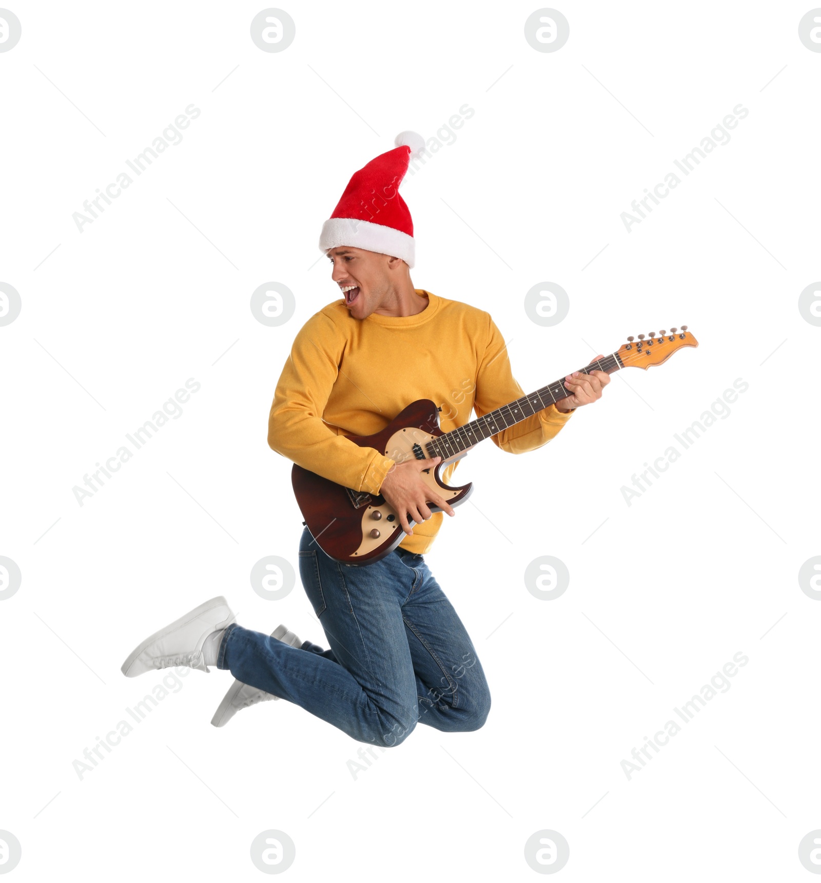 Photo of Man in Santa hat jumping with electric guitar on white background. Christmas music