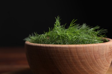 Bowl of fresh dill on black background, closeup