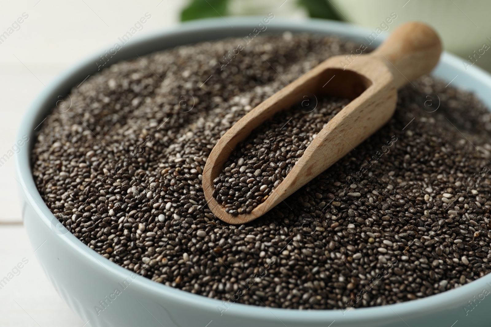 Photo of Bowl with chia seeds and wooden scoop, closeup