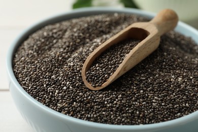 Photo of Bowl with chia seeds and wooden scoop, closeup
