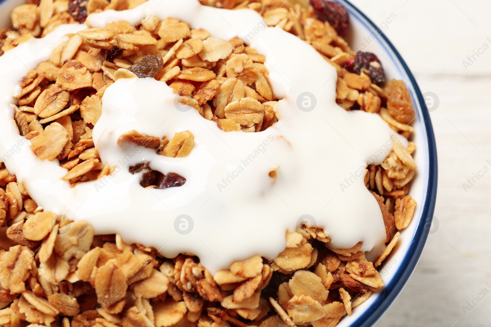 Photo of Muesli with yogurt in bowl, closeup. Delicious breakfast