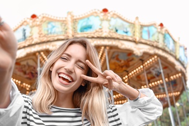 Photo of Attractive woman taking selfie in amusement park