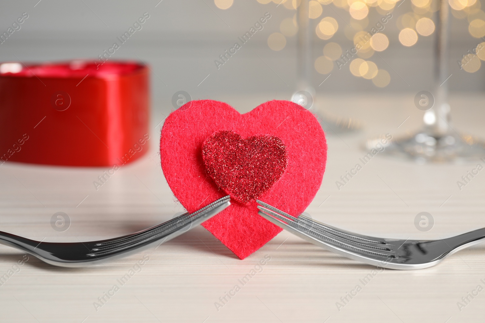 Photo of Forks and decorative heart on white table. Romantic place setting