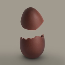 Image of Broken milk chocolate egg on grey background