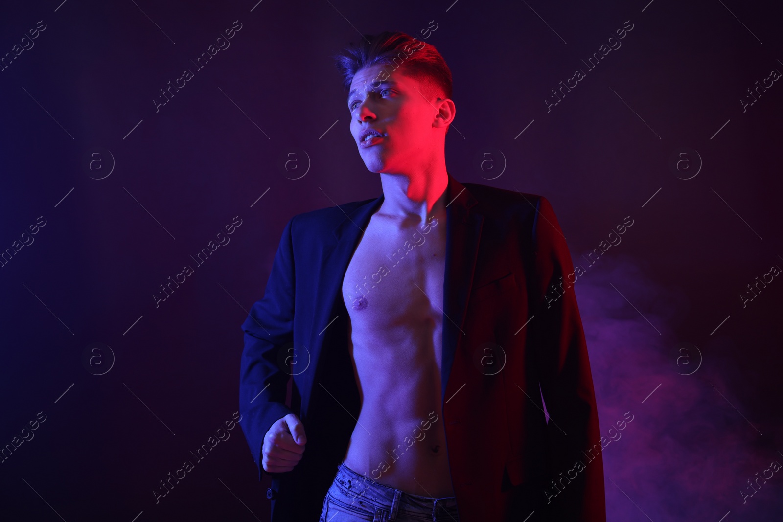 Photo of Sexy young man in neon lights with smoke effect