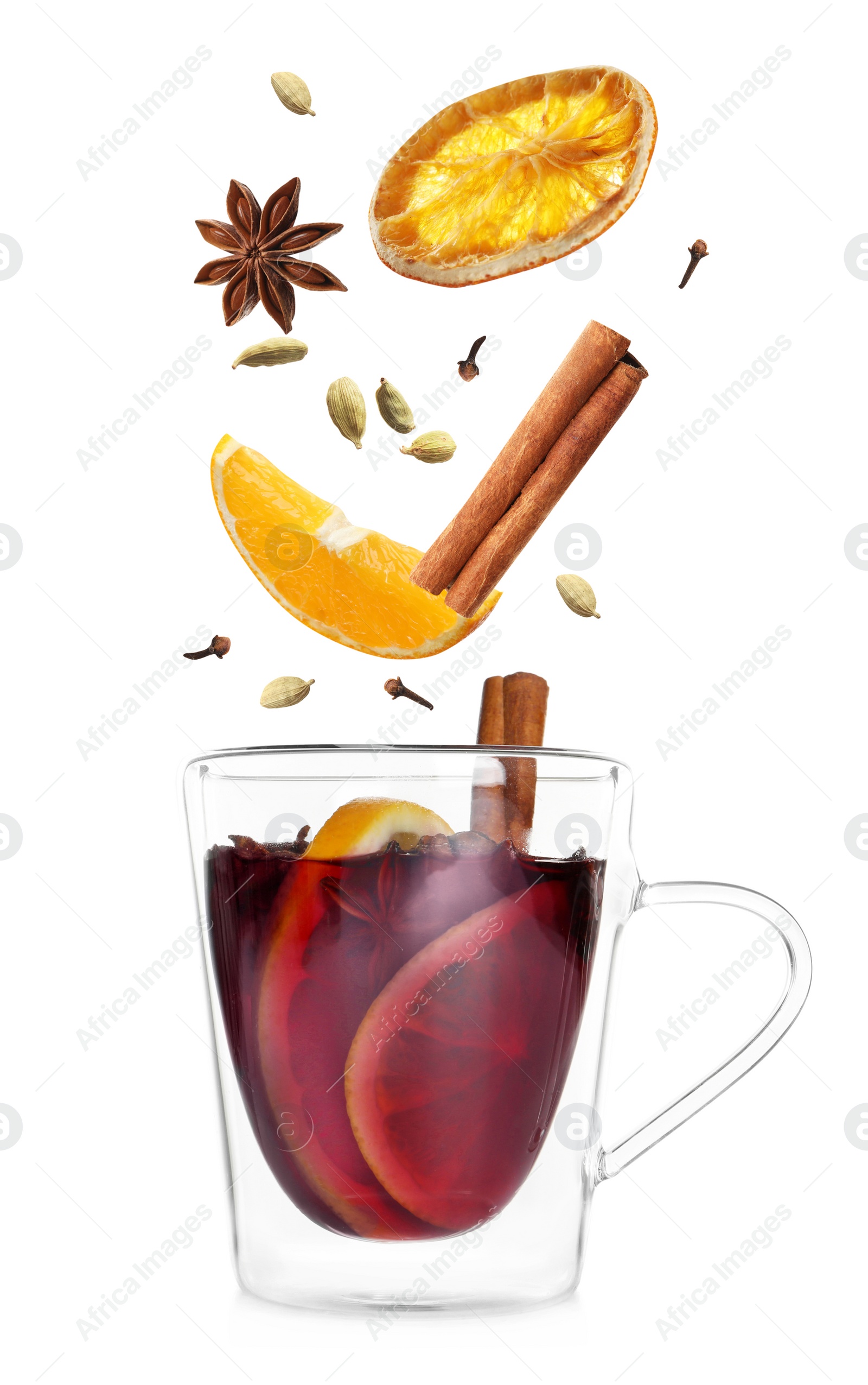 Image of Cut orange and different spices falling into glass cup of mulled wine on white background 