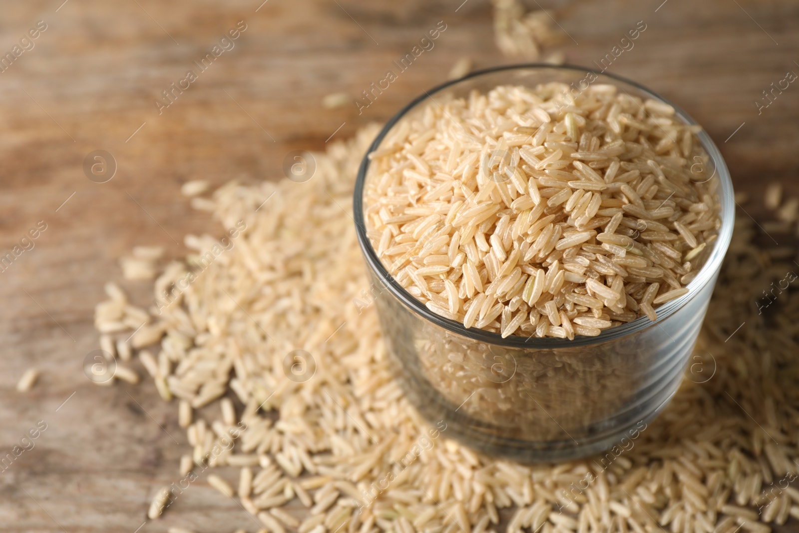 Photo of Brown rice in glass on table. Space for text